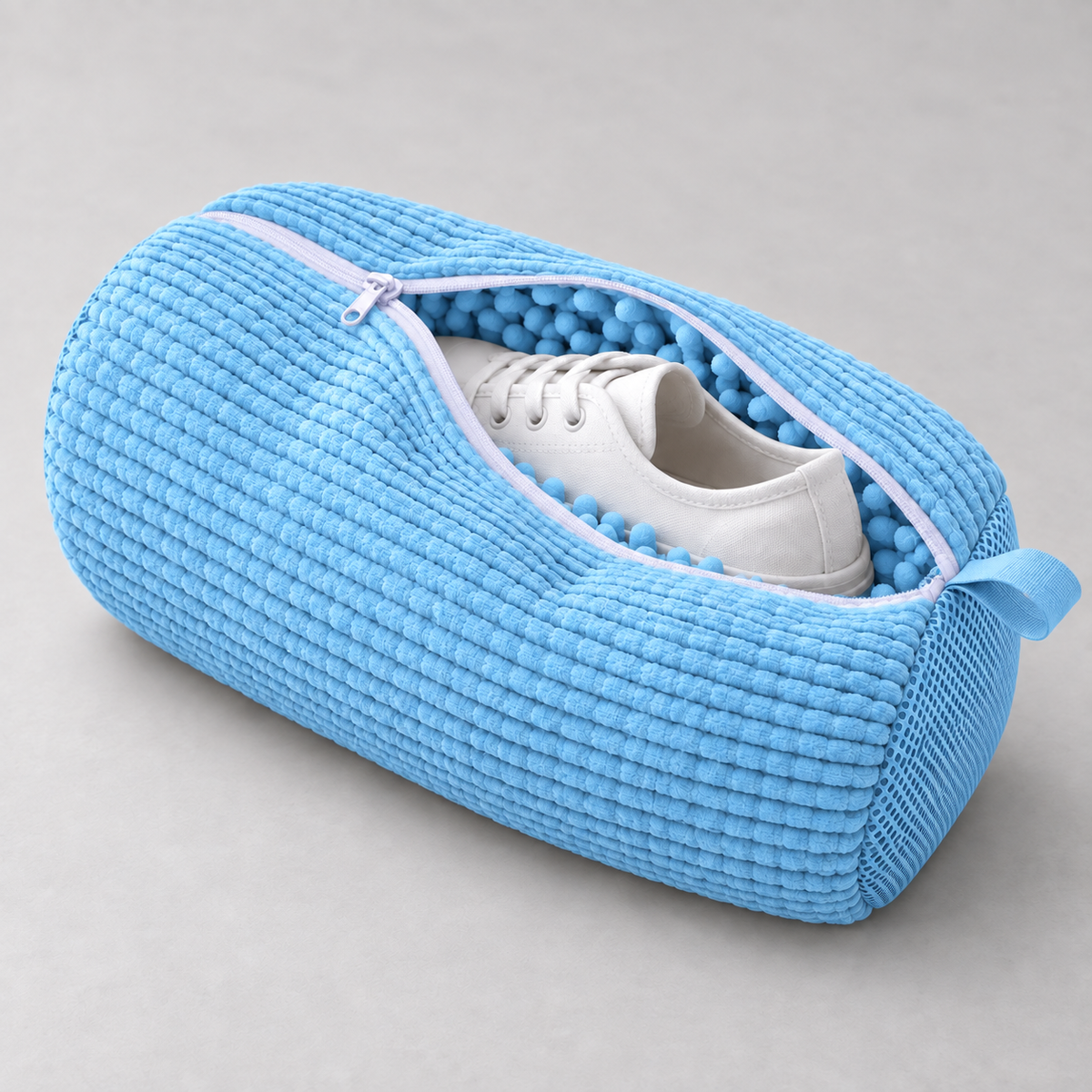 Canvas sneaker placed inside the open CloudWash bag, ready to zip closed